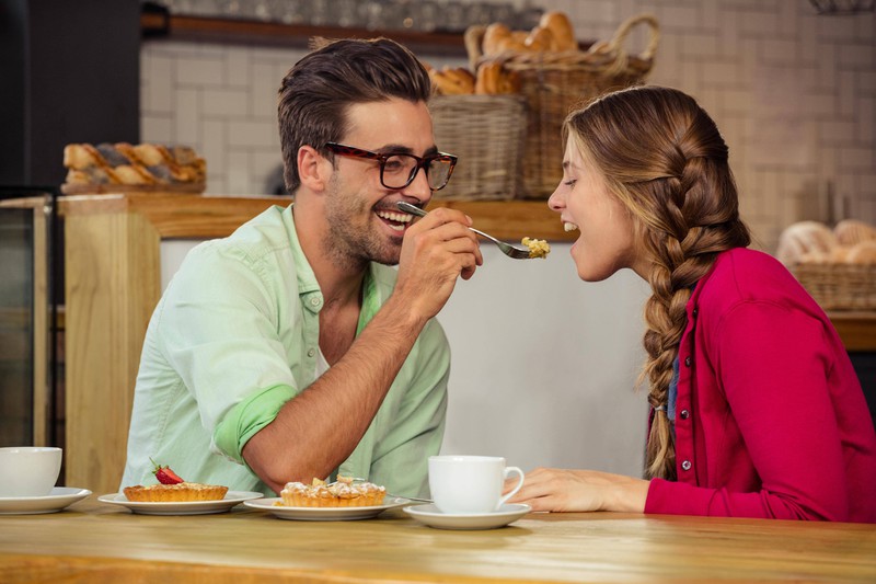 A lovestruck couple shares a piece of cake.