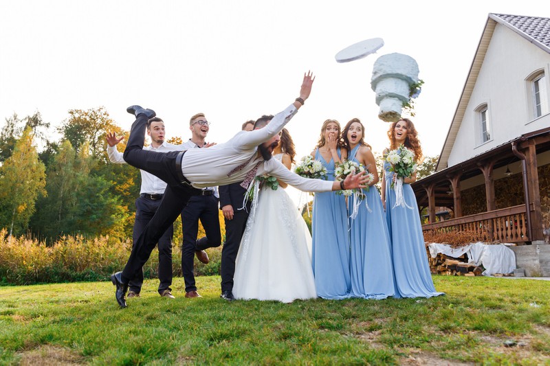 A wedding party is shocked by a man who drops the expensive wedding cake.