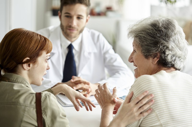 A doctors explains a situation to two patients.