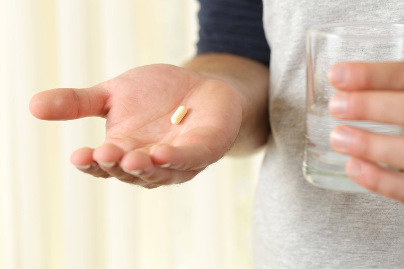 A patient is holding a pill in her hand.