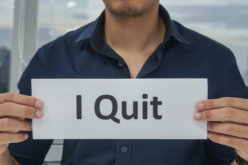 A person holding a sign reading "I Quit".