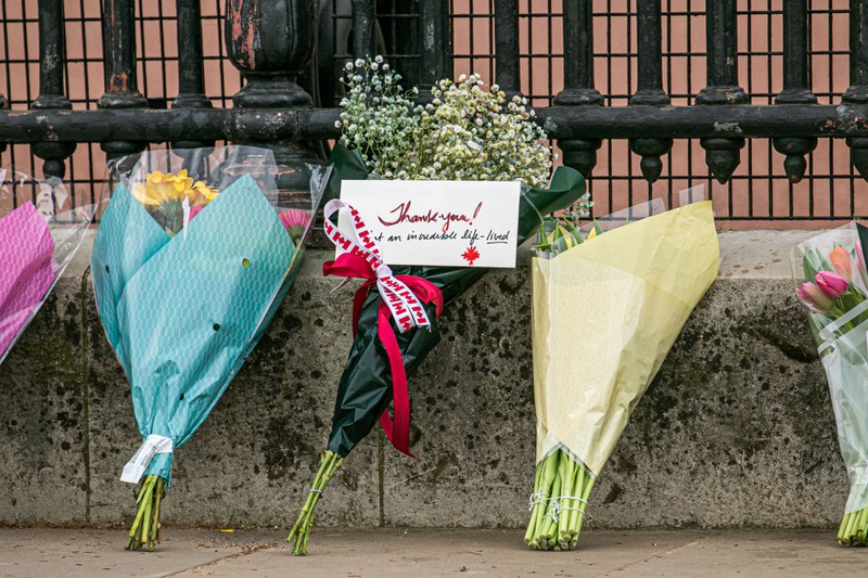 Mourners place flowers and kind messages in front of Buckingham Palace.