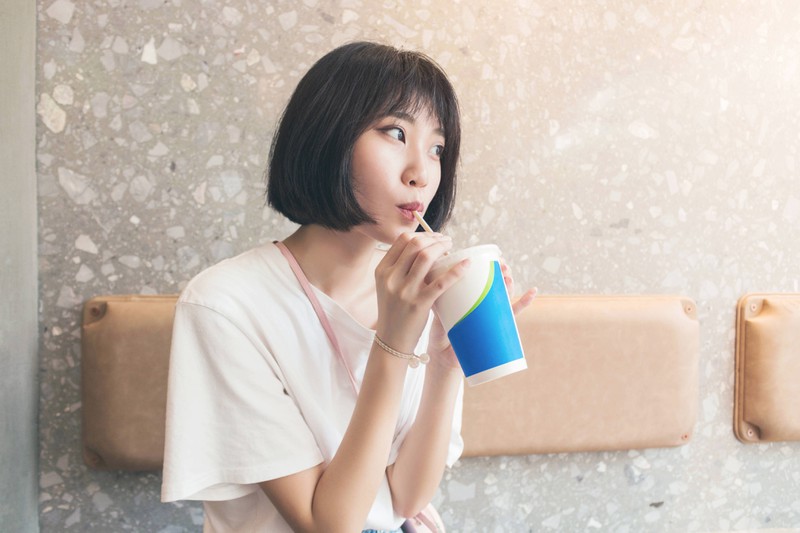 A woman enjoys a Coke light.