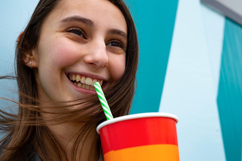 This woman is happy because she just had a sugary soft drink.