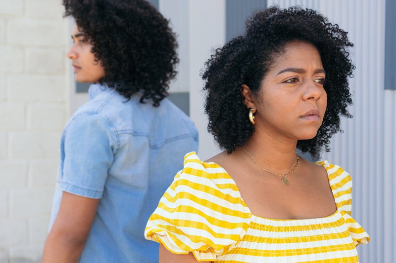 Side view disconnected ethnic couple having conflict and misunderstanding in relationships standing turned away from each other